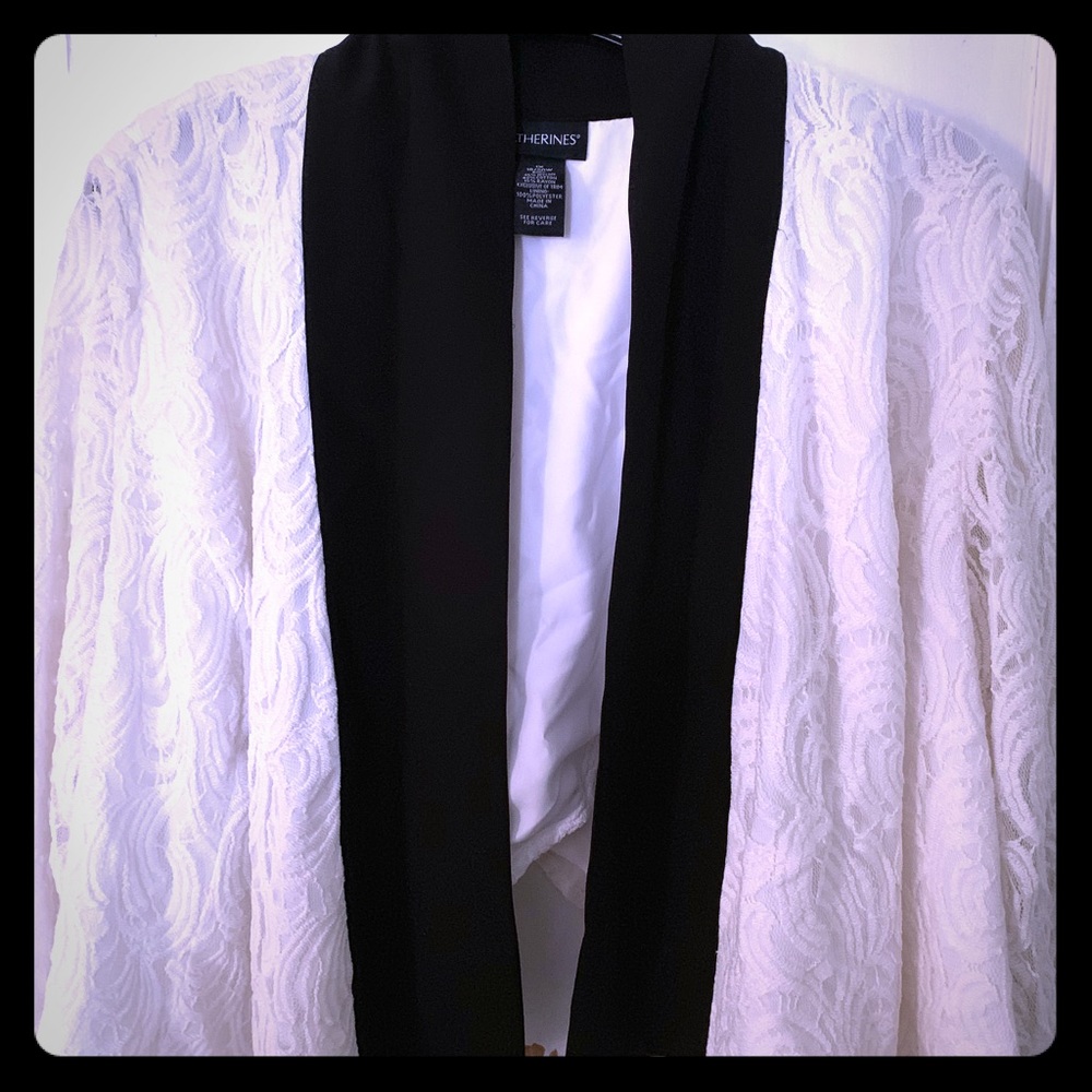 White cropped blazer with black trim.